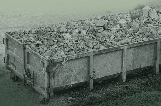 Benne de chantier pleine de gravats illustrant la gestion des déchets et les bonnes pratiques en matière de tri sur les sites de construction