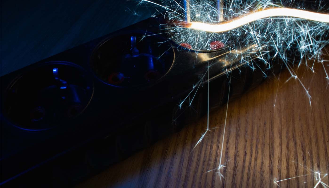 Court-circuit électrique sur une multiprise provoqué par l’humidité, illustrant les dangers de l’électricité en milieu humide